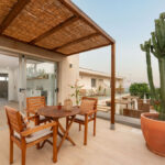 Exterior de los apartamentos Mångata Gran Canaria con vista de sillas y mesa exteriores y vista parcial del interior