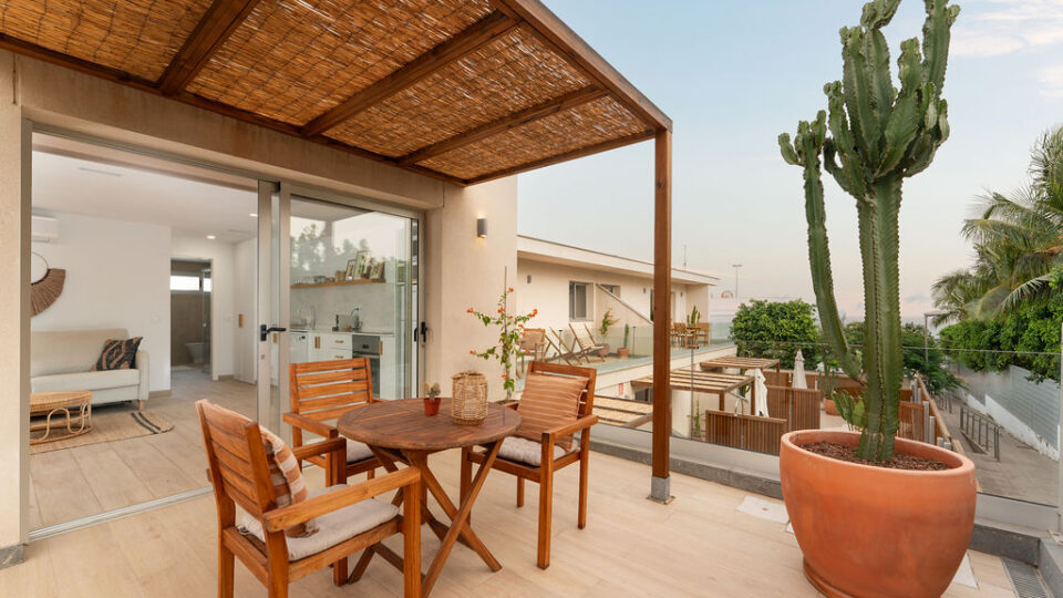 Exterior de los apartamentos Mångata Gran Canaria con vista de sillas y mesa exteriores y vista parcial del interior