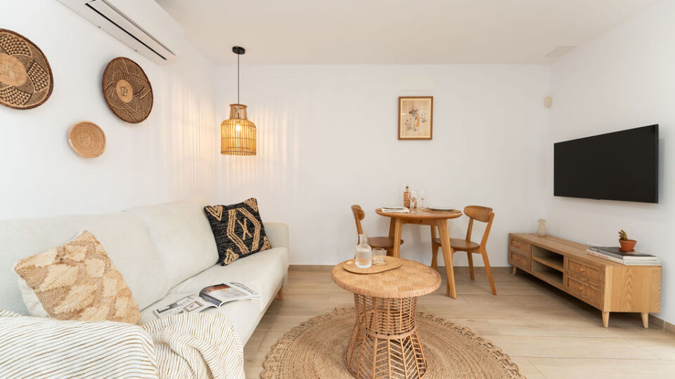 Interior de los apartamentos Mångata Gran Canaria con vista del salón interior con sofá, mesa y Smart TV