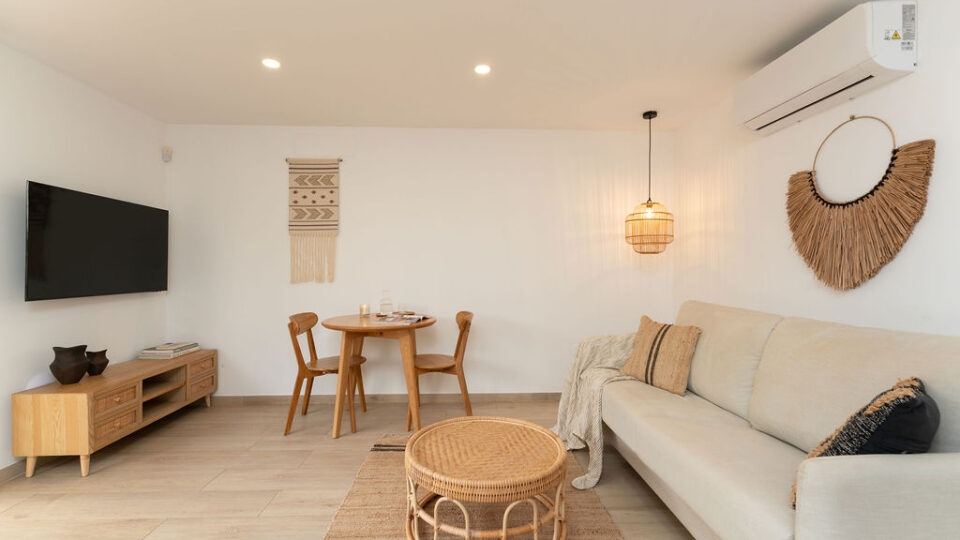 Interior de los apartamentos Mångata Gran Canaria con vista del salón interior con sofá, mesa y Smart TV