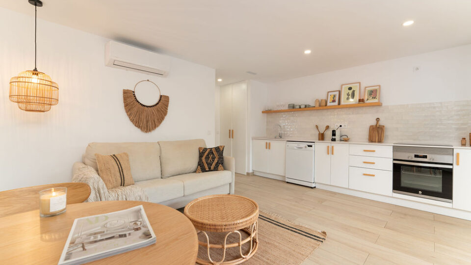 Interior de los apartamentos Mångata Gran Canaria con vista del salón interior con sofá, mesa y la cocina